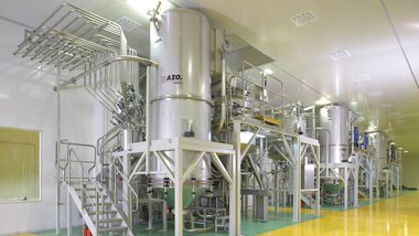 Vista de la zona de producción con la mezcladora de vacío y las básculas transportadoras