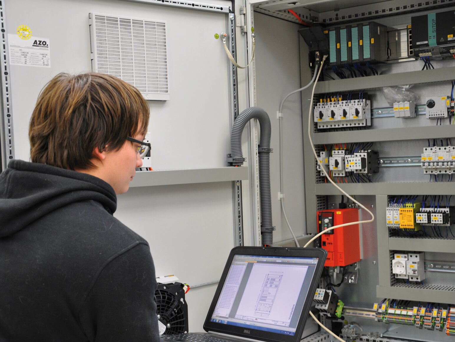 Service technicians with laptop control cabinet